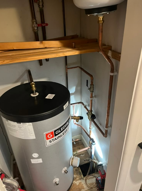 Gledhill stainless-steel hot-water cylinder and copper pipework in a cupboard
